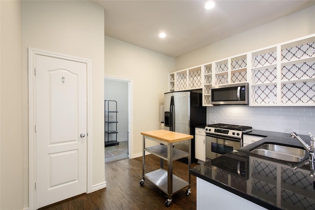 kitchen with appliances with stainless steel finishes, dark hardwood / wood-style flooring, sink, and decorative backsplash