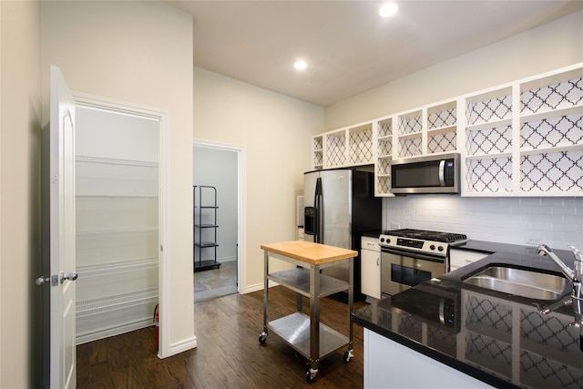 kitchen featuring sink, dark hardwood / wood-style floors, kitchen peninsula, stainless steel appliances, and decorative backsplash