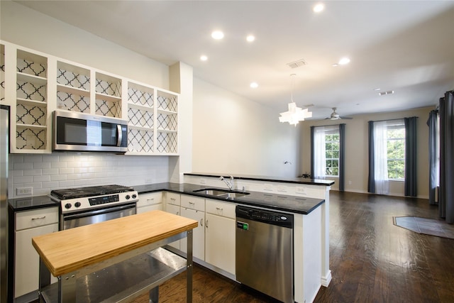 kitchen with white cabinetry, sink, kitchen peninsula, and appliances with stainless steel finishes