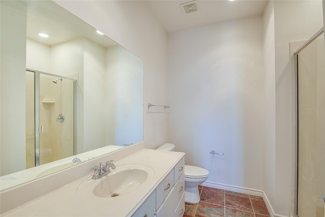 bathroom featuring vanity, toilet, and a shower with shower door