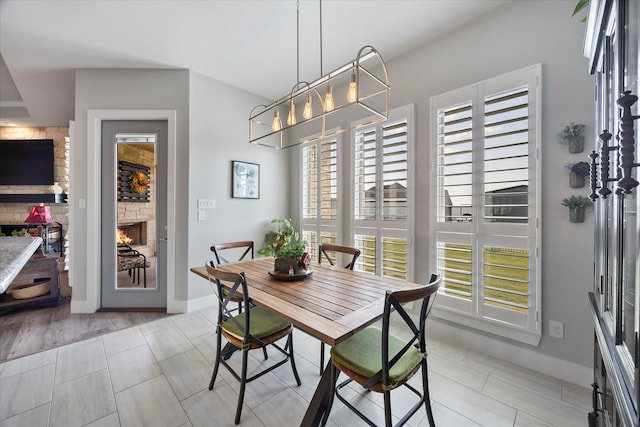 dining area featuring a fireplace and a chandelier