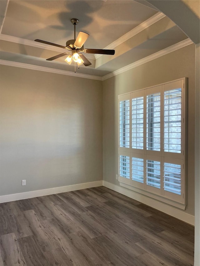 empty room featuring ceiling fan, crown molding, a tray ceiling, and dark wood-type flooring