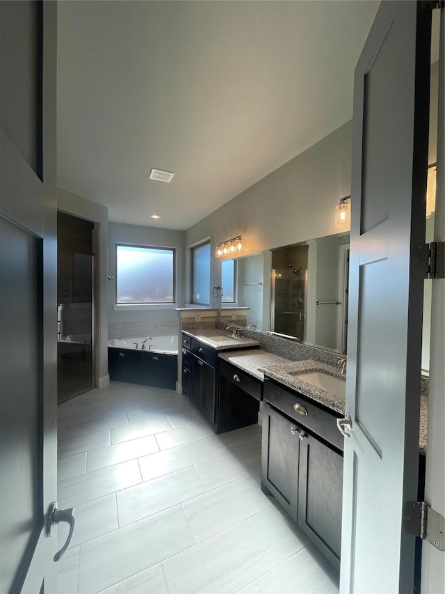 bathroom with tile patterned floors, vanity, and plus walk in shower