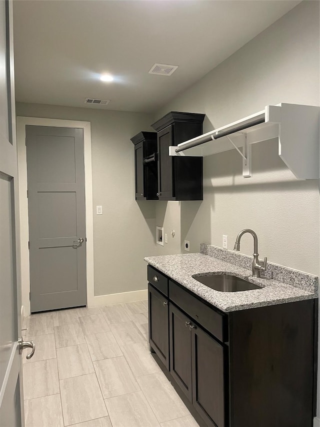 kitchen featuring light stone countertops and sink