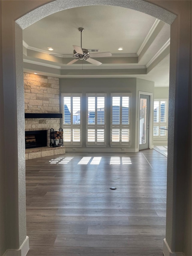 unfurnished living room featuring hardwood / wood-style floors, crown molding, and a tray ceiling