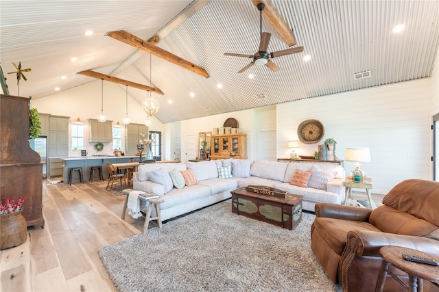 living room with beamed ceiling, ceiling fan, light hardwood / wood-style floors, and high vaulted ceiling