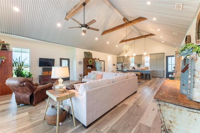 living room with beam ceiling, ceiling fan with notable chandelier, high vaulted ceiling, and light hardwood / wood-style flooring