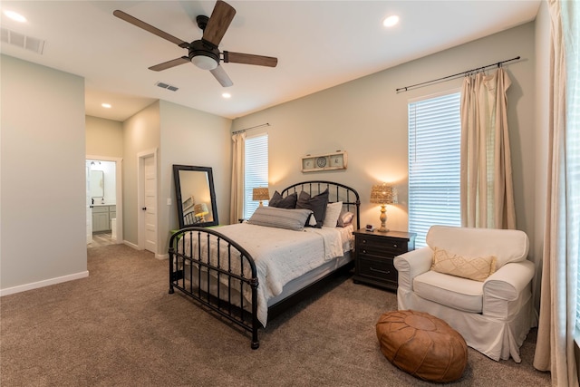 carpeted bedroom with multiple windows, connected bathroom, and ceiling fan