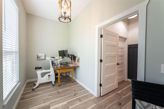 office space featuring wood-type flooring and an inviting chandelier