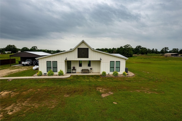 rear view of house with a lawn and a carport