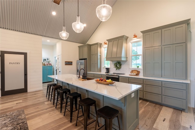 kitchen with a kitchen bar, pendant lighting, stainless steel appliances, and a large island