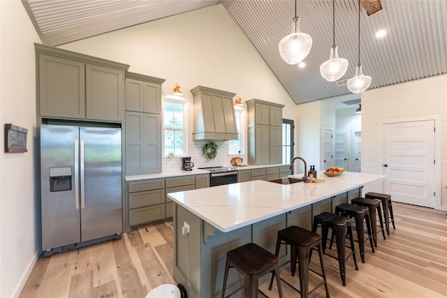 kitchen featuring tasteful backsplash, premium range hood, stainless steel appliances, a spacious island, and pendant lighting