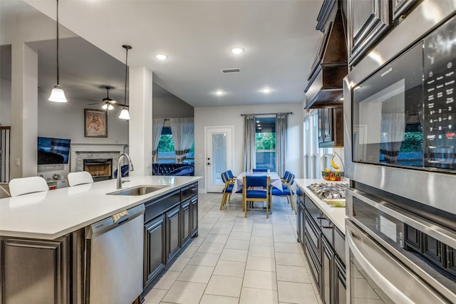 kitchen with sink, decorative light fixtures, dark brown cabinets, and appliances with stainless steel finishes