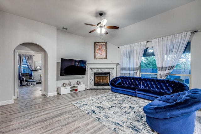 living room featuring hardwood / wood-style flooring, ceiling fan, lofted ceiling, and a fireplace