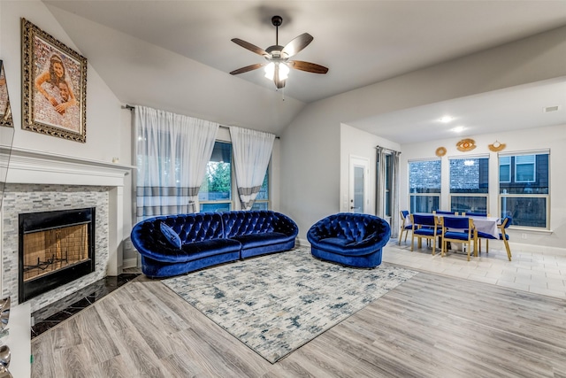 living room featuring ceiling fan, lofted ceiling, a fireplace, and hardwood / wood-style floors