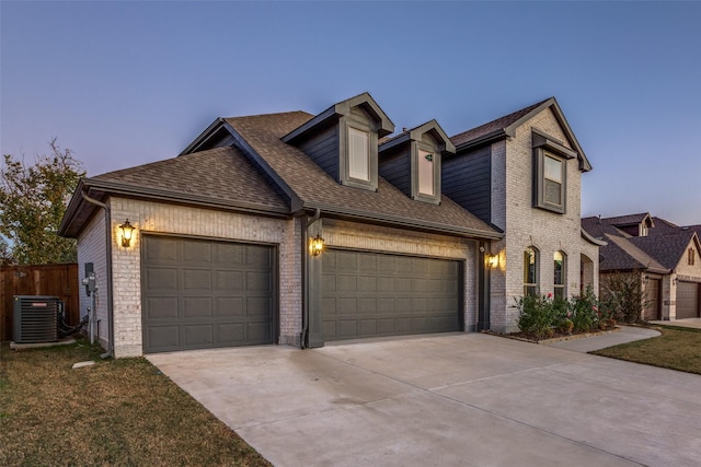 view of front of home with a garage and central AC