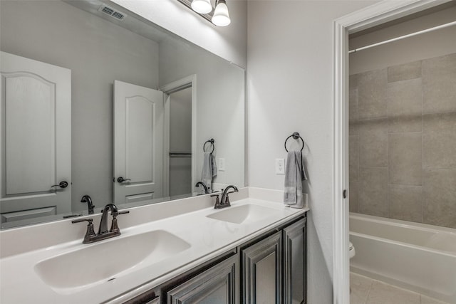 full bathroom featuring tile patterned floors, vanity, toilet, and tiled shower / bath combo