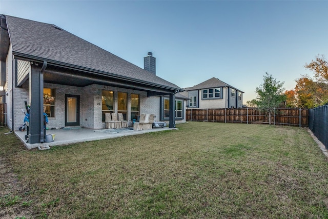 back of house with a patio and a lawn