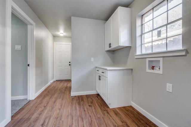 laundry room featuring cabinets, hookup for a washing machine, and light hardwood / wood-style flooring