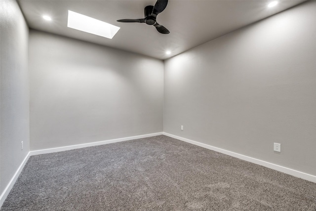 unfurnished room featuring carpet, ceiling fan, and a skylight