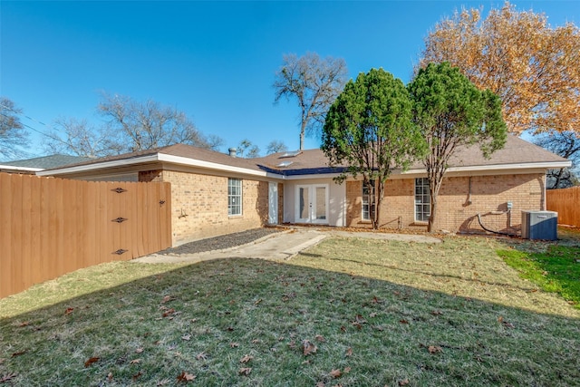 back of property featuring cooling unit, a yard, and french doors