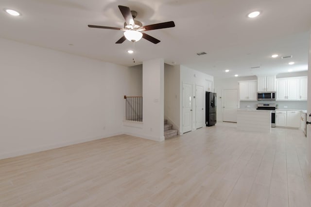 unfurnished living room with ceiling fan and light hardwood / wood-style floors