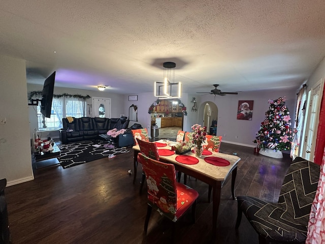 dining room with a textured ceiling, ceiling fan, and dark wood-type flooring