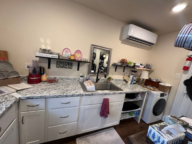 kitchen featuring a wall mounted air conditioner, dark wood-type flooring, sink, white cabinets, and washer / clothes dryer