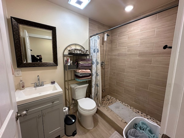 bathroom featuring hardwood / wood-style floors, vanity, toilet, and walk in shower