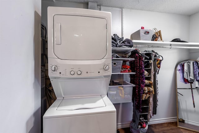 washroom with dark hardwood / wood-style floors, a textured ceiling, and stacked washer / dryer