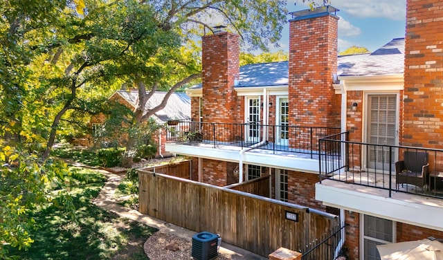 rear view of house with a balcony and central AC unit