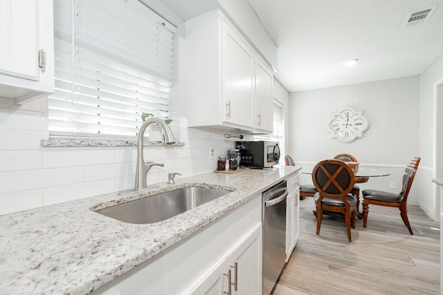 kitchen with backsplash, white cabinetry, and appliances with stainless steel finishes