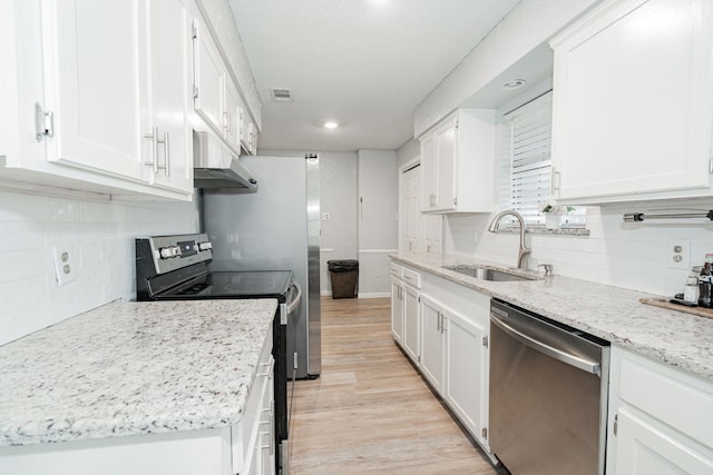 kitchen featuring white cabinetry, appliances with stainless steel finishes, light hardwood / wood-style floors, and sink