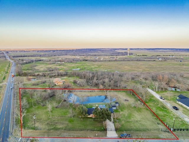 aerial view at dusk with a rural view and a water view