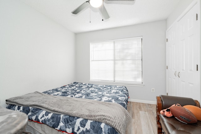 bedroom featuring ceiling fan, light hardwood / wood-style floors, and a closet