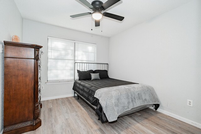 bedroom with ceiling fan and light wood-type flooring