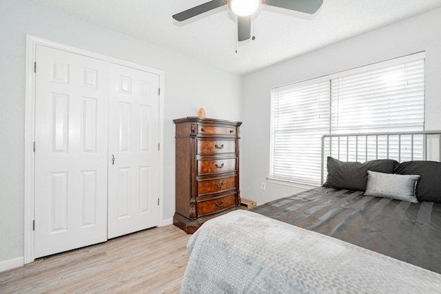 bedroom featuring multiple windows, a closet, light hardwood / wood-style flooring, and ceiling fan