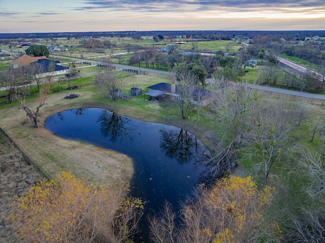 aerial view at dusk with a water view and a rural view
