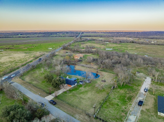 aerial view at dusk with a rural view and a water view