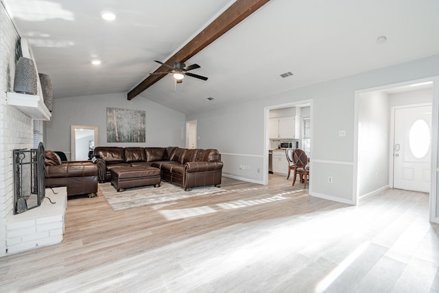 living room featuring ceiling fan, a fireplace, lofted ceiling with beams, and light hardwood / wood-style floors