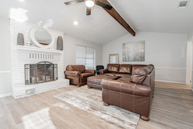 living room with vaulted ceiling with beams, light hardwood / wood-style floors, a brick fireplace, and ceiling fan