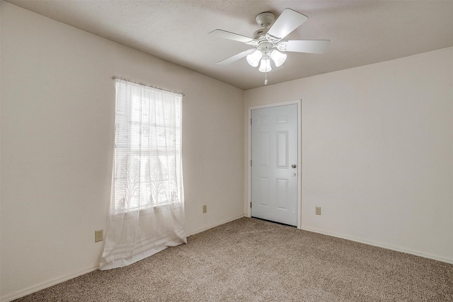 carpeted spare room with ceiling fan