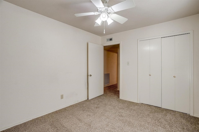 unfurnished bedroom featuring light carpet, a closet, and ceiling fan