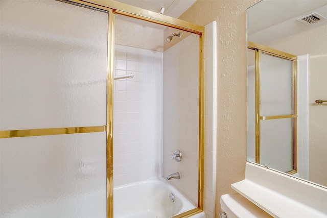 bathroom featuring shower / bath combination with glass door and toilet