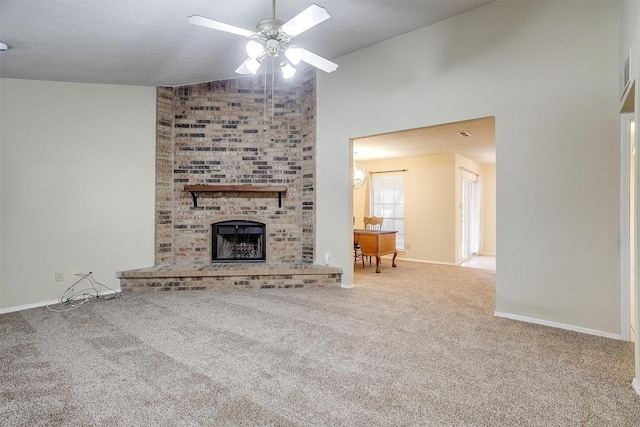 unfurnished living room featuring ceiling fan, a brick fireplace, vaulted ceiling, and carpet