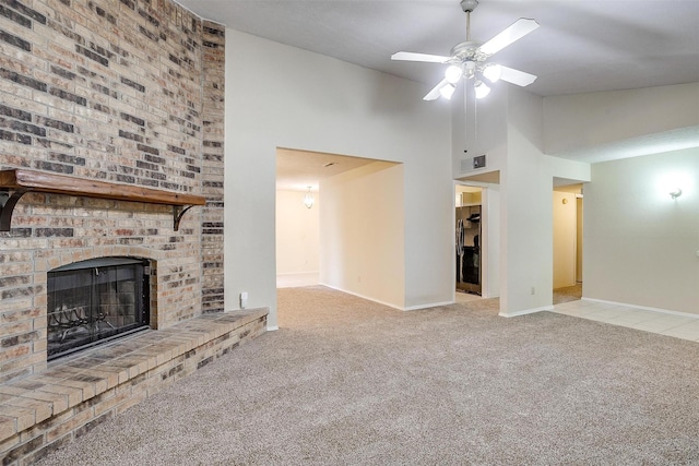 unfurnished living room with ceiling fan, light colored carpet, high vaulted ceiling, and a brick fireplace