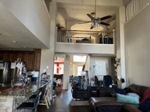 living room featuring ceiling fan and a high ceiling