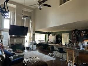 living room with ceiling fan and a towering ceiling