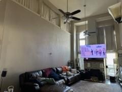 living room with ceiling fan and a fireplace