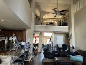 living room with ceiling fan and a high ceiling